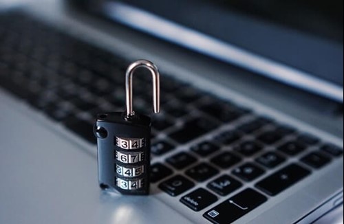 a padlock next to a laptop symbolising cyber security